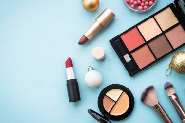 Mavi arka planda ürünler ve Noel süslemeleri var. Tatil alışverişi. Kopyalama alanı olan düz resim.