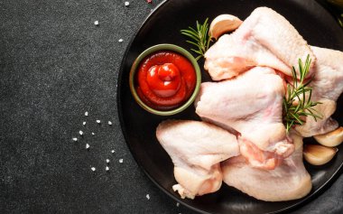 Çiğ tavuk eti, bitkiler ve siyah üzerine baharatlar. Tavuk fileto, kanat, but. Kopyalama alanı olan üst görünüm.