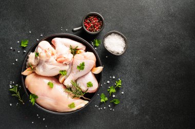 Çiğ tavuk eti, bitkiler ve siyah üzerine baharatlar. Tavuk fileto, kanat, but. Kopyalama alanı olan üst görünüm.