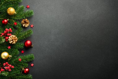 Köknar ağacı ve tatil süslemeleri olan siyah Noel arkaplanı.