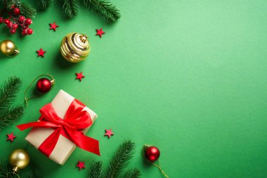 Tatil süslemeleriyle birlikte Noel hediyesi. Düz arkaplan yeşile yatıyordu.