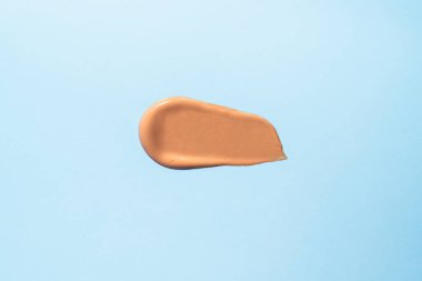 Örnekler, lekeler, mavi arka planda temel krem dokusu. En üst görüntü.