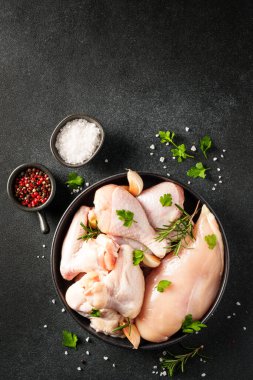 Çiğ tavuk eti, bitkiler ve siyah üzerine baharatlar. Tavuk fileto, kanat, but. Kopyalama alanı olan üst görünüm.