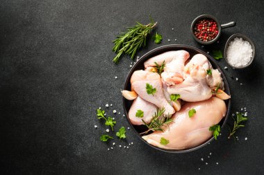 Çiğ tavuk eti, bitkiler ve siyah üzerine baharatlar. Tavuk fileto, kanat, but. Kopyalama alanı olan üst görünüm.