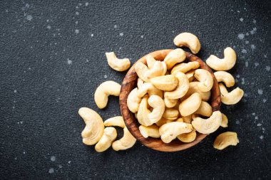 Siyah arka planda kasede kaju fıstığı. Metin için boşluk ile düz uzandı.