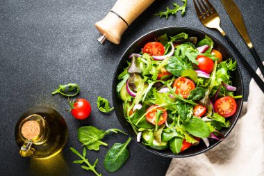 Salata yapraklı yeşil salata ve siyah arka planda sebze. Kopyalama alanı olan üst görünüm.