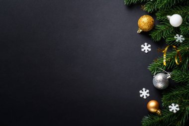 Noel tebrik kartı. Beyaz ve altın renkli tatil süslemeleri olan bir Noel arkaplanı. Simsiyah kopyalama alanı olan düz uzandı.