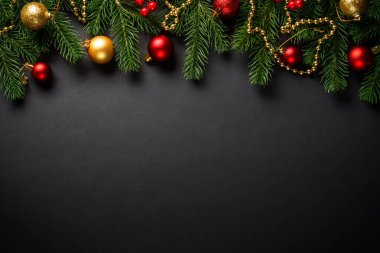 Siyah Noel arkaplanı dümdüz uzanıyordu. Siyah arka planda tatil süslemeleri olan Noel ağacı.