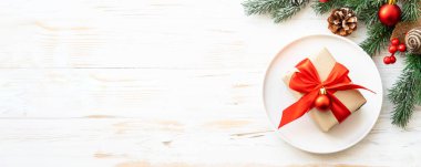 Noel yemeği geçmişi olan bir Noel masası. Beyaz tabak ve dekorasyonlar en üstte. Uzun biçim.