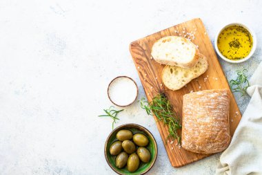 Ciabatta ekmeği ve zeytinyağı. Kopyalama alanı olan beyaz tablo üzerindeki üst görünüm.