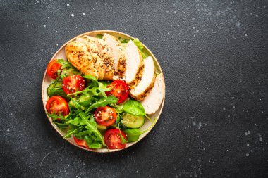 Siyah masada ızgara et ve sebzeli tavuk salatası. Kopyalama alanı olan üst görünüm.