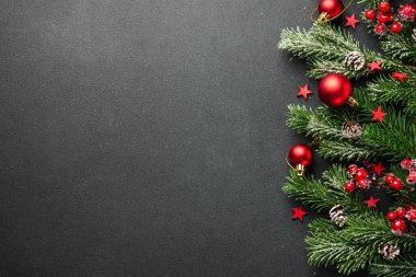 Noel arka planında köknar ağacı ve siyahların üzerinde tatil süslemeleri vardı. Tasarım için sace kopyala.