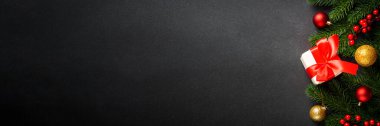 Noel arkaplanı, Noel ağacı, hediye kutusu ve siyahta tatil süslemeleri. Kopyalama alanı olan düz.