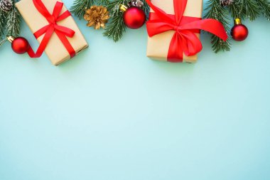 Mavi arka planda köknar ağacı olan Noel hediyeleri ve süslemeler. Kopyalama alanı olan düz resim.