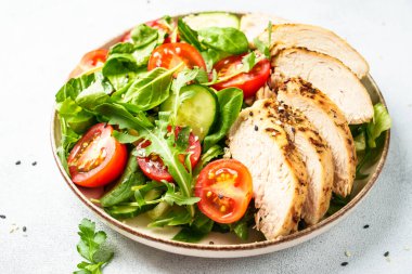 Beyaz masada kızarmış et ve sebzeli tavuk salatası..