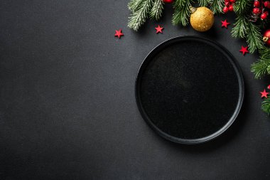 Noel masası. Noel yemeği, siyah üzerine zarif süslemeler olan bayram yemekleri. Kopyalama alanı olan düz.