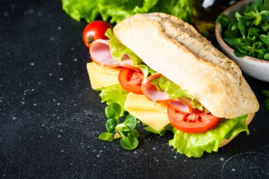 Marul, peynir, domates ve jambonlu sandviç. Sağlıklı fast food, kahvaltı ya da öğle yemeği. Kapat..
