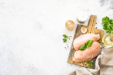 Tavuk fileto, beyaz arka planda baharatlı çiğ tavuk göğsü. Metin için boşluk olan üst görünüm.