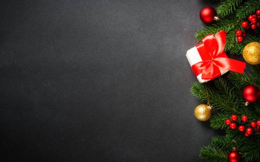 Siyahta Noel tebrik kartı. Noel ağacı ve hediye kutusu ve tatil süslemeleri düzdü..