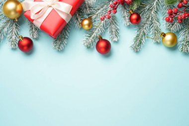 Noel arkaplanı düzdü. Kırmızı ve altın noel süsü tasarım için yer var..