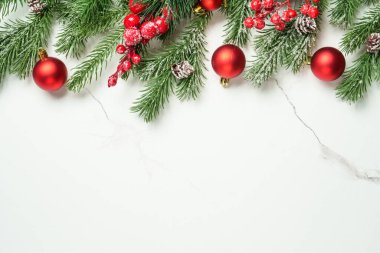 Beyaz üzerine Noel kompozisyonu. Noel kırmızı süslemeleri ve köknar ağacı. Kopyalama alanı olan üst görünüm.