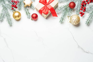 Noel arkaplanı düzdü. Kırmızı ve altın madalyalar ve beyaz üzerine köknar ağacı. Tasarım için alanı olan tebrik kartı.