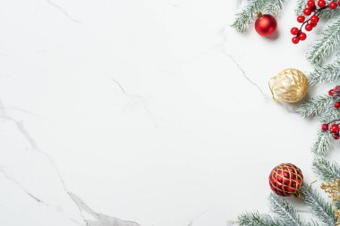 Noel arkaplanı ya da tebrik kartı. Beyaz mermer zemin üzerinde kırmızı ve altın süslemeler, mum ve köknar ağacı.