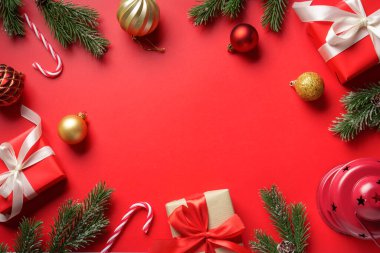 Hediyeler ve dekorasyonlarla Noel kompozisyonu. Kırmızı arkaplanda düz resim yatıyordu.