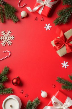 Kırmızı arka planda Noel hediyeleri. Hediye kutuları, köknar ağacı ve süslemeler..