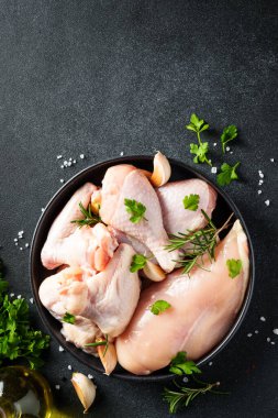 Çiğ tavuk eti, bitkiler ve siyah üzerine baharatlar. Tavuk fileto, kanat, but. Kopyalama alanı olan üst görünüm.