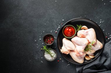 Çiğ tavuk eti, bitkiler ve siyah üzerine baharatlar. Tavuk fileto, kanat, but. Kopyalama alanı olan üst görünüm.