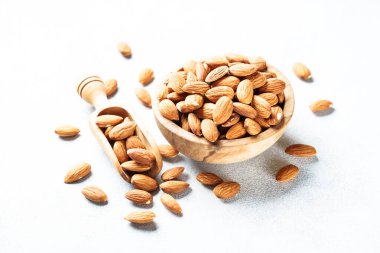 Almond nuts in wooden bowl at white background. Close up. clipart