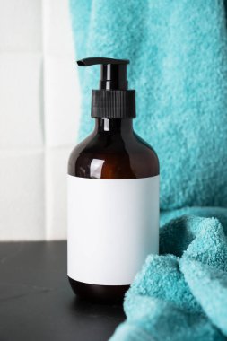 Banyoda sıvı sabun ve mavi havlu. Banyo aksesuarları..