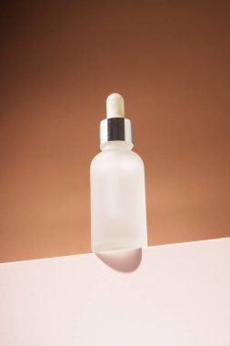 Serum şişesi podyumda. Doğal kozmetik nemlendirici, sağlıklı scin bakım ürünü.