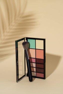 Göz falı paleti ve koyu gölgeli renkli arka planda fırçalar.