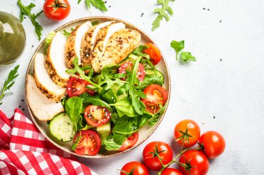 Beyaz masada ızgara et ve sebzeli tavuk salatası. Kopyalama alanı olan üst görünüm.