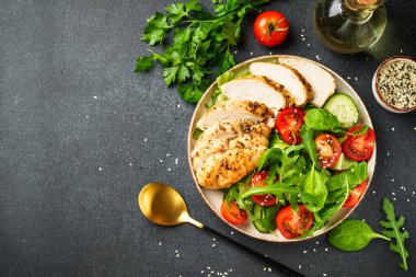 Siyah masada ızgara et ve sebzeli tavuk salatası. Kopyalama alanı olan üst görünüm.