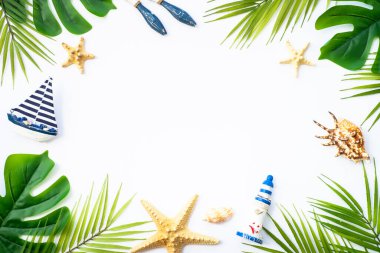 Yaz düzlüğü arka plandaydı. Yaz tatili ve seyahat konsepti. Palmiye yaprakları, deniz kabukları ve beyaz arka planda dekor.