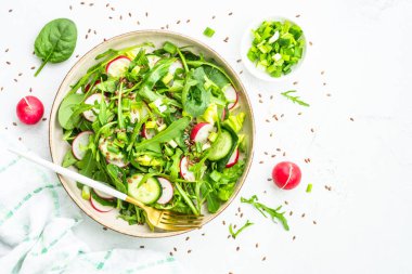 Ispanaklı yeşil salata, roka ve beyaz masada zeytinyağı ile turp. Kopyalama alanı olan üst görünüm.