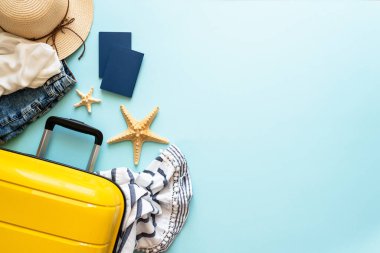 Seyahat geçmişi, yaz tatilleri. Çanta, pasaportlar, şapka ve mavi arka planda yaz örtüsü. Kopyalama alanı olan düz resim.