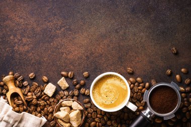 Cup of coffee, roasted coffee beans and filter holder at dark table. Flat lay with copy space.