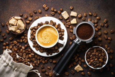 Bir fincan kahve, kavrulmuş kahve çekirdekleri ve koyu masada filtre tutacağı..