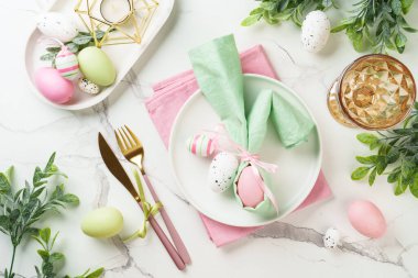 Beyaz arka planda Paskalya sofrası. Beyaz tabak, çatal bıçak takımı ve paskalya süslemeleri. Düz yatıyordu.