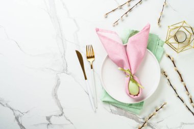 Beyaz arka planda süslemeleri olan Paskalya yemekleri. Beyaz tabak, çatal bıçak takımı ve komik paskalya süslemeleri..