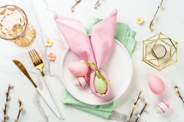 Paskalya yemeği geçmişi, beyaz arka planda tatil masası ayarı. Beyaz tabak, çatal bıçak takımı ve paskalya süslemeleri..