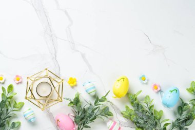 Paskalya düzlüğü arka plandaydı. Paskalya yumurtaları ve beyazın üzerindeki süslemeler. Kopyalama alanı olan düz.