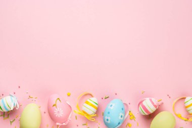 Paskalya yumurtaları ve pembe arka planda süslemeler. Kopyalama alanı olan düz resim.
