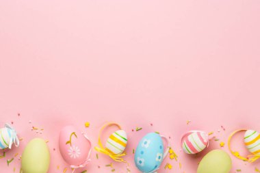 Paskalya yumurtaları ve pembe arka planda süslemeler. Kopyalama alanı olan düz resim.