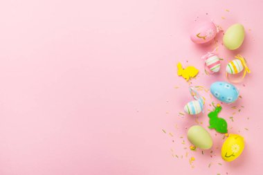Paskalya yumurtaları ve pembe arka planda süslemeler. Kopyalama alanı olan düz resim.