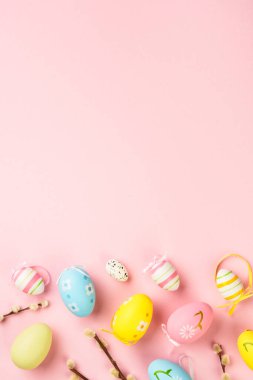 Paskalya yumurtaları ve pembe arka planda süslemeler. Kopyalama alanı olan düz resim.